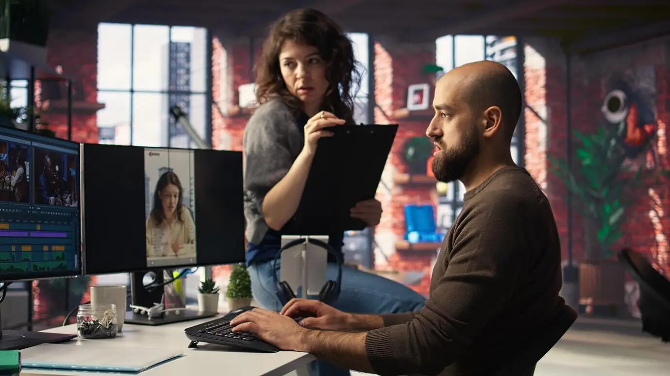 Ein Team bespricht Content-Strategie und Trends, während es Videomaterial auf Computern sichtet.