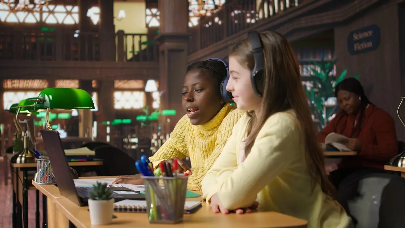 Mädchen, die in der Bibliothek an einem Onlinekurs teilnehmen, schließen sich einem Live-Video-Webinar an.